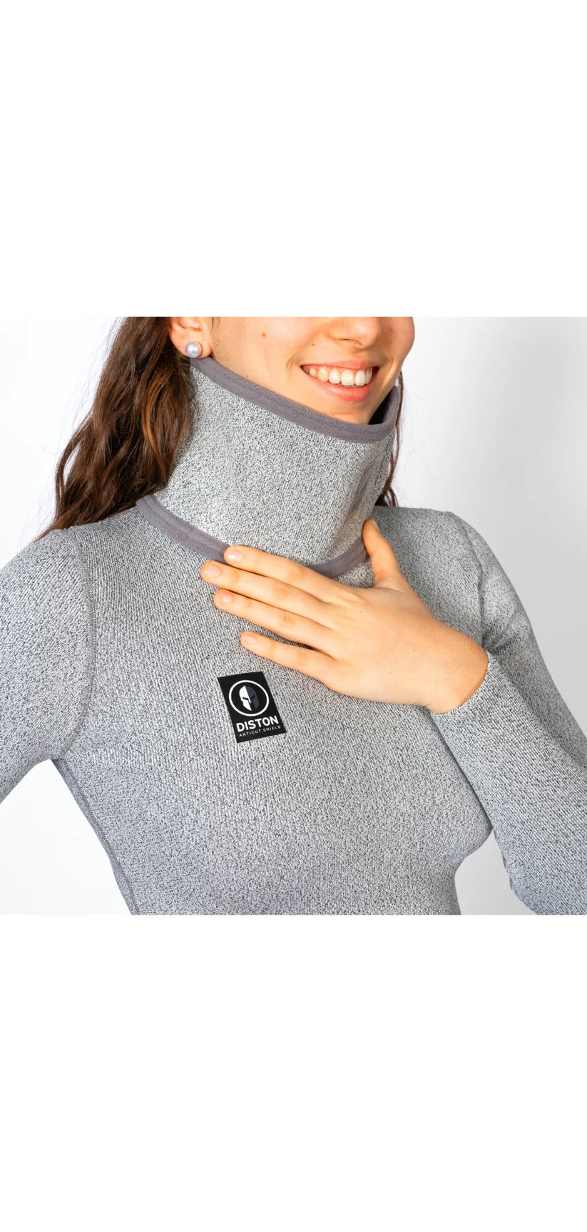 Eine lächelnde Frau trägt das Diston WC Cut Resistant Top Women - 4FIS Stars in CRG - CORE / Racing Fit mit einem Diston-Logoaufnäher - ideal für Skirennläuferinnen, die Wert auf Stil und Sicherheit legen.