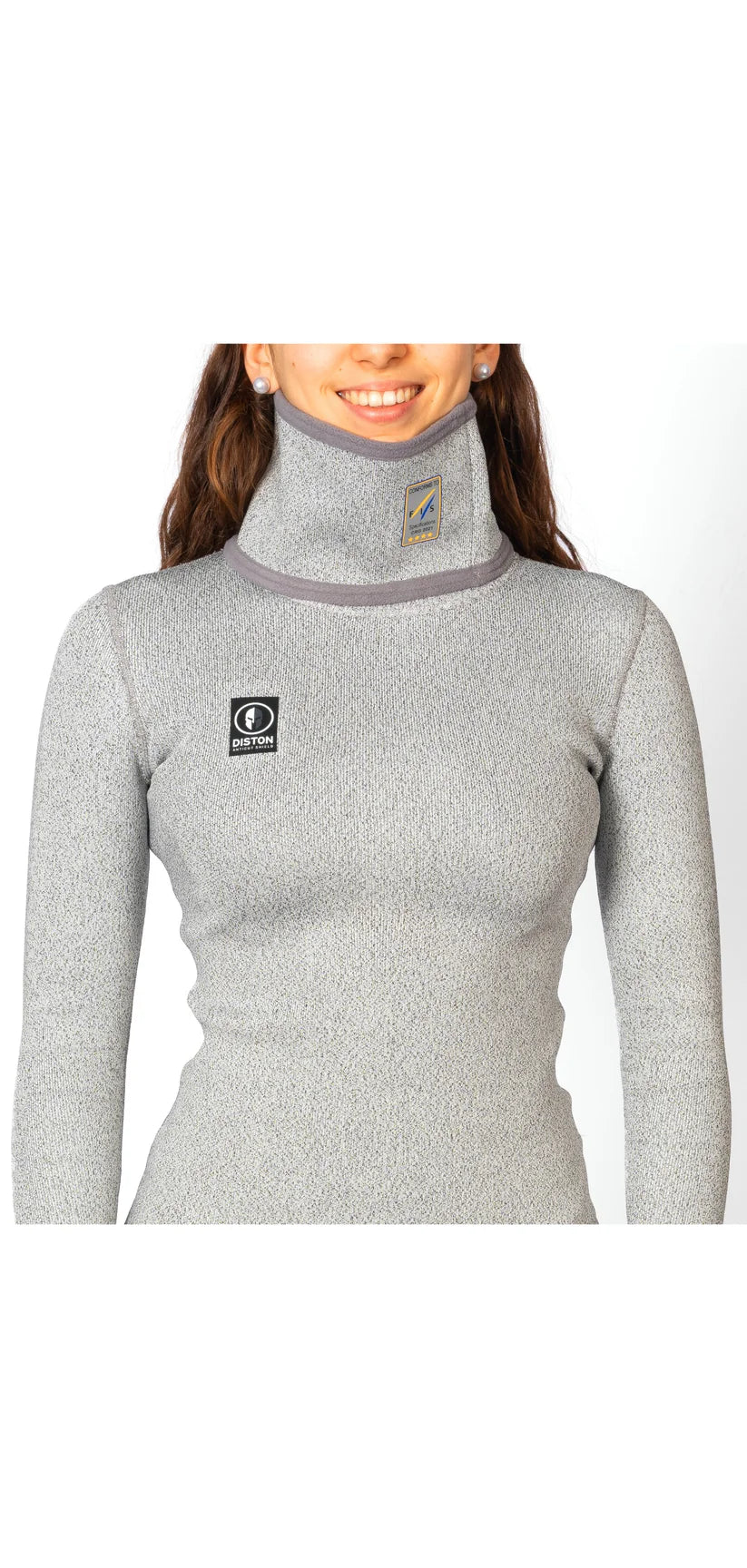 Eine Person trägt ein hellgraues, langärmeliges Diston DISTON WC Cut Resistant Top Women - 4FIS Stars in CRG - CORE / Racing Fit mit zwei kleinen Brustlogos; nur die untere Hälfte des Gesichts ist sichtbar.