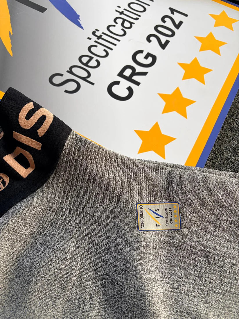 Eine Nahaufnahme der Diston DISTON WC Cut Resistant Unterhose Women - 5FIS Stars in CRG - PRO/Racing Compression Fit, mit einem Zertifizierungsetikett vorne und einem "Specification CRG 2021"-Zeichen sowie fünf gelben Sternen hinten.