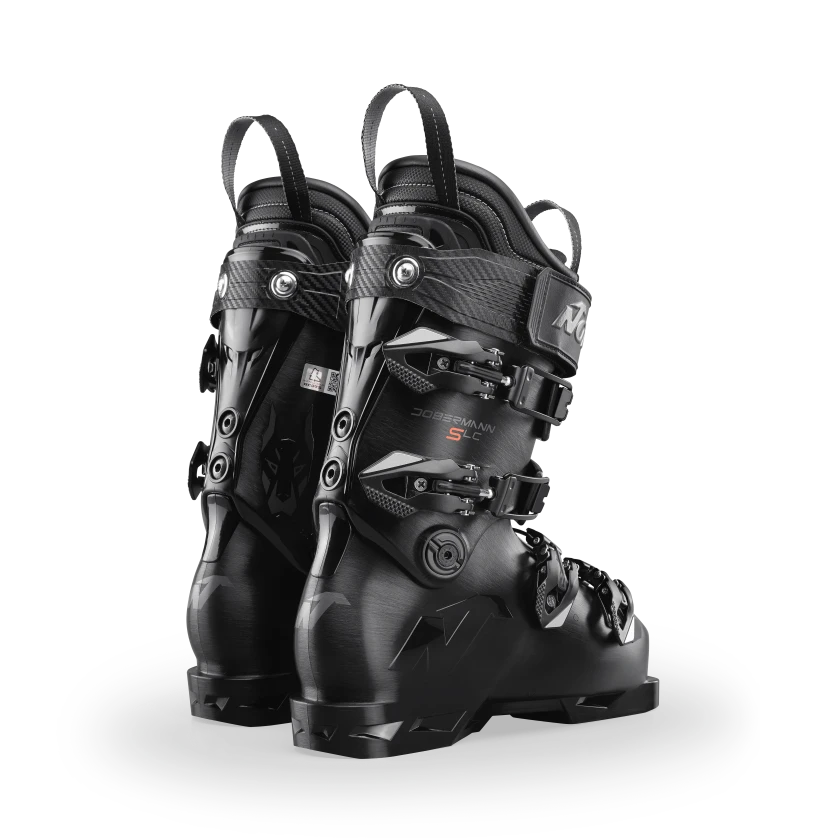 Die Nordica DOBERMANN 5 SOFT L.C. BLACK Skischuhe verfügen über mehrere Schnallen und Riemen, die aufrecht und leicht angewinkelt auf einem hellgrauen Hintergrund präsentiert werden - ideal für Skifahrer, die hohe Leistung suchen.