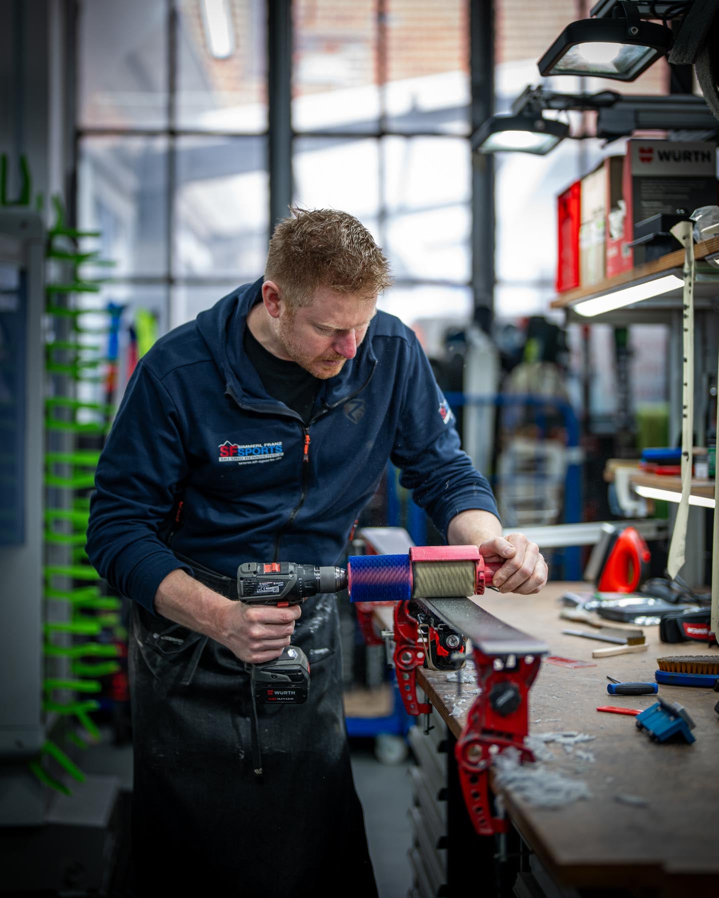 Ein Mitarbeiter bei SF Sports bearbeitet den Belag eines Skis mit einer Rotorbürste. Diese Methode sorgt für einen glatten, präzisen Feinschliff für optimale Gleitfähigkeit.