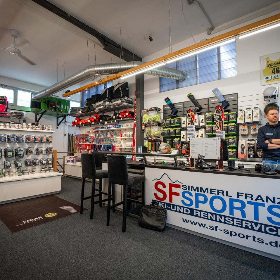 SF Sports Geschäft, ein Fachgeschäft in Gilching, spezialisiert auf Wintersportausrüstung für Skifahren und Snowboarding. Im Laden gibt es eine große Auswahl an Skiern, Snowboards, Skischuhen und Zubehör, die in einer modernen und einladenden Atmosphäre präsentiert werden.