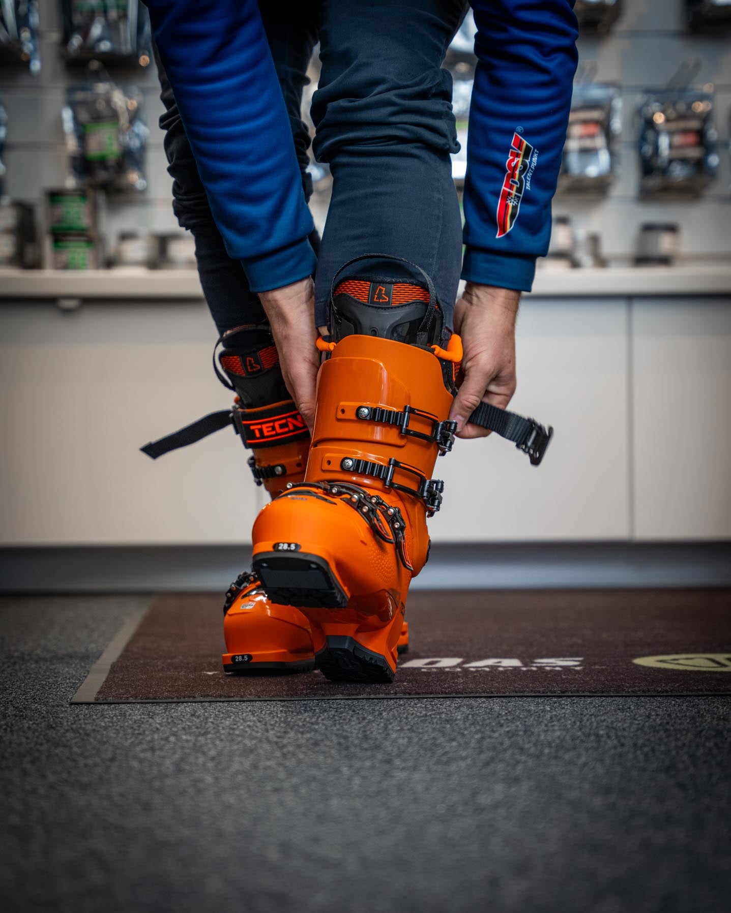 Ein Kunde probiert Skischuhe an, die für den Rennsport individuell angepasst werden. Perfekt sitzende Schuhe bieten Stabilität, Sicherheit und optimale Performance auf der Rennstrecke.