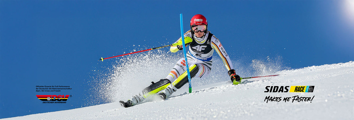 Lena Duerr faehrt dynamisch im Slalomrennen bei strahlend blauem Himmel, ausgestattet mit Head Ski, Sidas Race Ausruestung und DSV Rennanzug – perfekte Technik auf Weltcupniveau