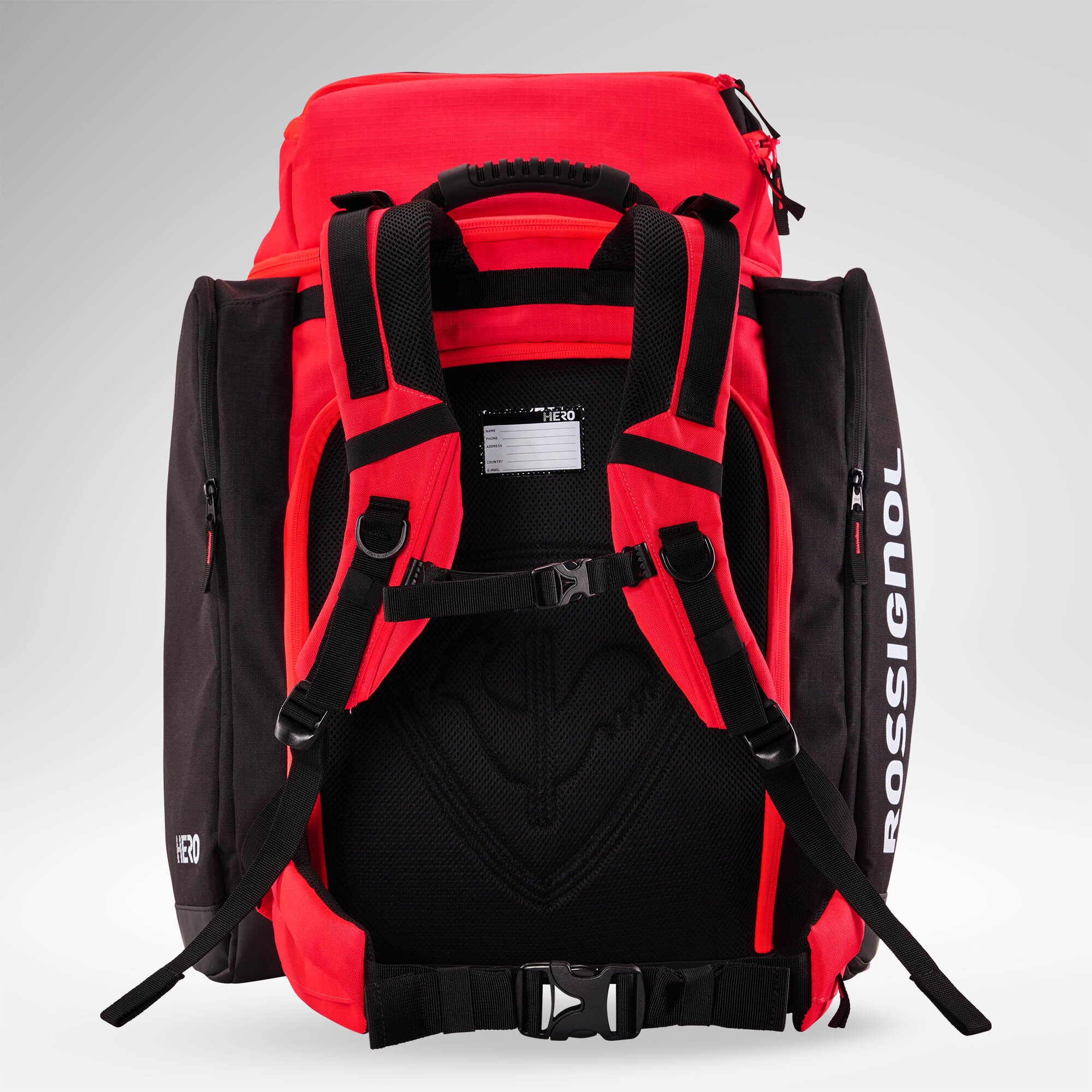 Ein rot-schwarzer „Rossignol HERO ATHLETES BAG“ ist aufrecht stehend von hinten zu sehen, mit gepolsterten Schultergurten, einem Brustgurt und Seitentaschen mit Reißverschluss vor einem hellgrauen Hintergrund. Dieser wasserdichte Skirucksack von Rossignol schützt Ihre Skirennausrüstung unterwegs und sorgt für Ordnung.