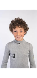 Ein kleines Kind mit lockigen braunen Haaren lächelt in die Kamera. Es trägt ein hellgraues Diston Cut Resistant Top Junior - 4FIS Stars in CRG - CORE / Racing Fit mit schwarzem DISTON-Text am Kragen und einem Logo auf der Brust vor einem schlichten weißen Hintergrund.