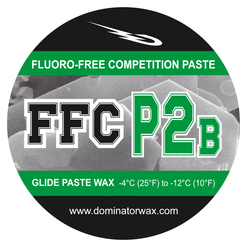 Rundes Produktetikett für Dominator-Wachs. Text: "Fluorfreie Wettkampfpaste, FFC P2B, Gleitpastenwachs -4°C (25°F) bis -12°C (10°F), www.dominatorwax.com." Schwarzes, grünes und weißes Design.