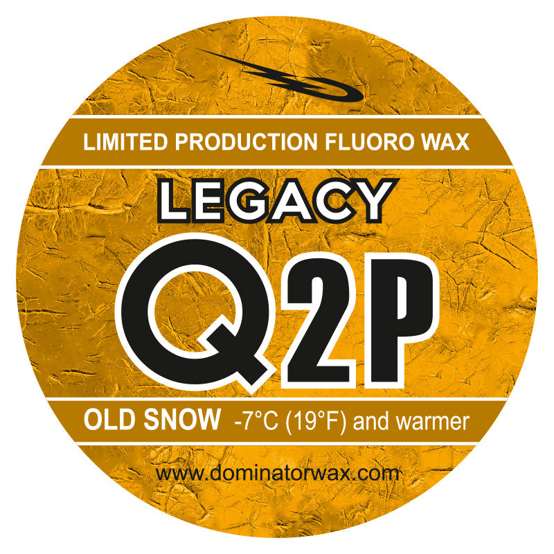 Rundes goldenes Etikett mit Text: LIMITIERTE PRODUKTION FLUORO WACHS. LEGACY Q2P. OLD SNOW -7°C (19°F) und wärmer. www.dominatorwax.com und ein Swoosh-Design auf der Oberseite.