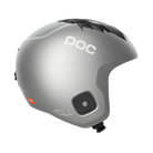 Der POC Sports Skull Dura Jr Marco Odermatt Ed. ist ein matt silberner Skihelm mit schwarzem geometrischem Design, sichtbaren Ohrenschlitzen, Kinnriemen und der Unterschrift von Marco Odermatt am unteren Rand.