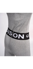 Eine Person trägt eine Diston DISTON Cut Resistant Unterhose Junior - 4FIS Stars in CRG - CORE / Racing Fit in Hellgrau mit schwarzem Bund mit weißem Text und Logo, dargestellt vom unteren Rücken- und Hüftbereich vor einem einfarbigen Hintergrund.