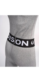 Eine Person trägt eine Diston DISTON Cut Resistant Unterhose Junior - 4FIS Stars in CRG - CORE / Racing Fit in Hellgrau mit schwarzem Bund mit weißem Text und Logo, dargestellt vom unteren Rücken- und Hüftbereich vor einem einfarbigen Hintergrund.