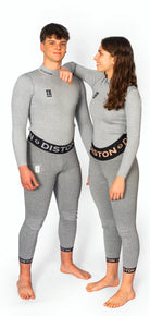 Ein Mann und eine Frau stehen nebeneinander, beide in grauem Diston WC Cut Resistant Top Men - 4FIS Stars in CRG - CORE / Racing Fit, inspiriert von der Schnittschutzkleidung der Skirennfahrer, vor einem weißen Hintergrund.