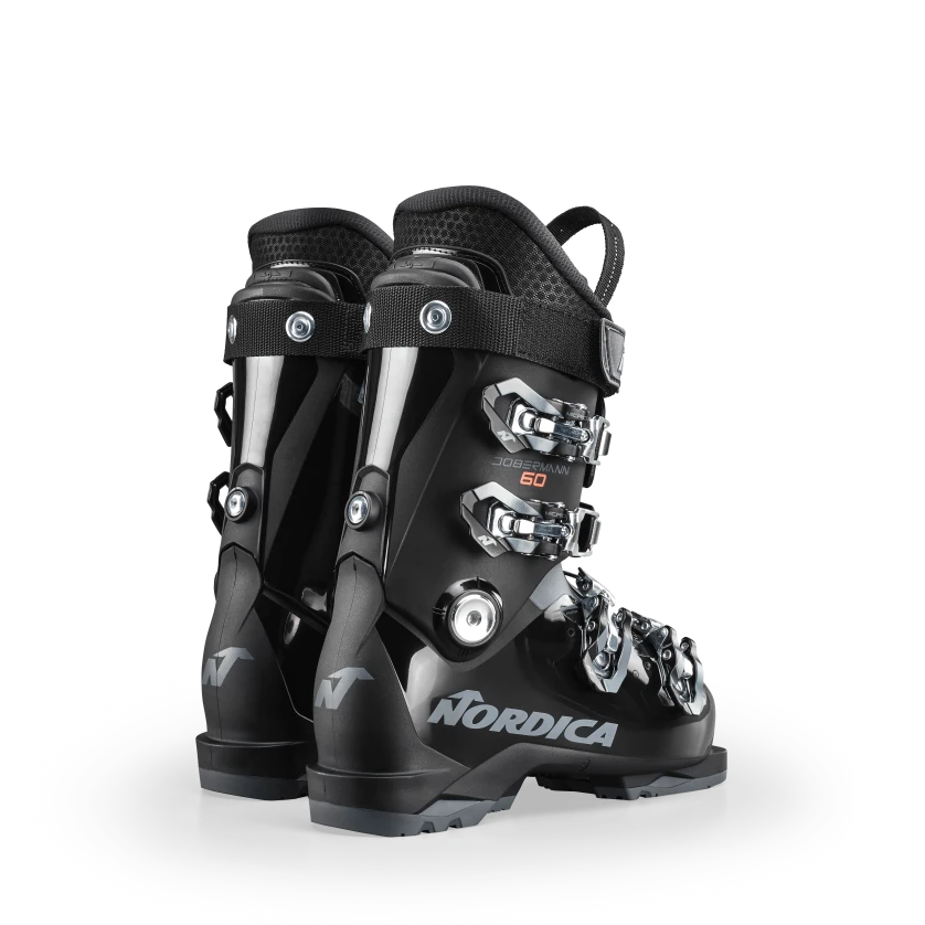 Ein Paar schwarze Nordica DOBERMANN GP 60 Junior-Skischuhe mit silbernen Schnallen, von hinten gesehen auf weißem Hintergrund. Zu den Merkmalen gehören das Nordica-Logo, eine robuste Kunststoffkonstruktion und verstellbare Riemen und Schnallen.