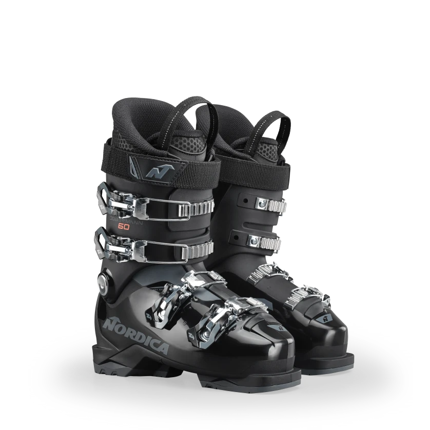 Ein Paar Nordica DOBERMANN GP 60 Junior-Skischuhe in Schwarz mit je vier silbernen Schnallen und schwarzem gepolstertem Innenschuh sind nebeneinander auf einem weißen Hintergrund platziert.