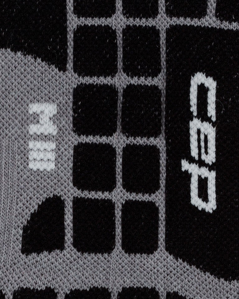 Nahaufnahme der CEP Ski Ultralight Socken 3.0 für Herren in Schwarz und Grau mit einem Gittermuster und weiß aufgestickten Symbolen.