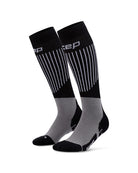 Ein Paar CEP Ski Ultralight Socken 3.0 für Damen in Schwarz und Grau, mit weißen vertikalen Streifen und dem CEP-Markennamen am oberen Bund.
