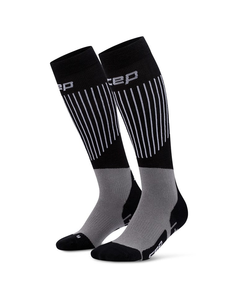 Ein Paar CEP Ski Ultralight Socken 3.0 für Herren in Schwarz und Grau, mit weißen vertikalen Streifen an der Wade und einem CEP-Logo im oberen Bereich.