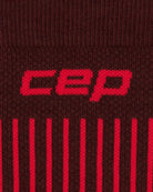 Nahaufnahme des braunen und dunkelroten Strickstoffs der CEP Ski Ultralight Socken 3.0 für Herren, auf dem der Markenname „CEP“ in kräftigen roten Buchstaben über vertikalen roten Streifen zu sehen ist.