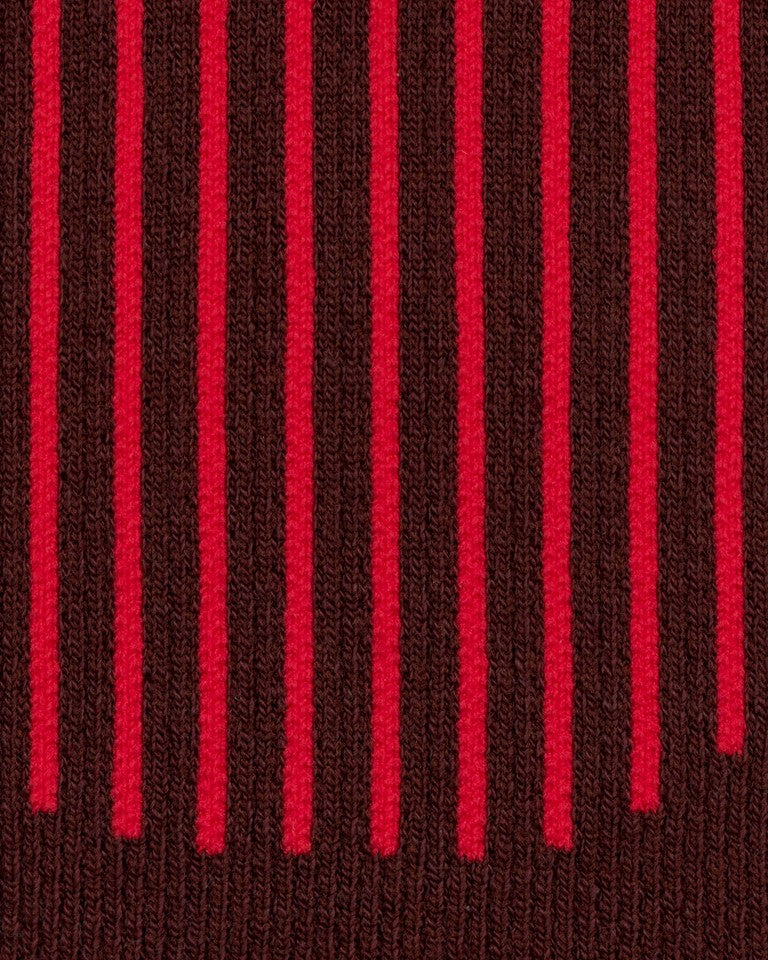 Eine Nahaufnahme der CEP Ski Ultralight Socken 3.0 (Damen) von CEP, die ein Strickmuster mit vertikalen dunkelroten Streifen auf braunem Hintergrund zeigen.