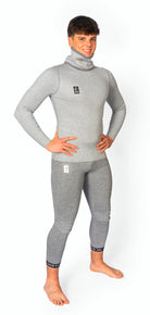 Ein lächelnder Mann steht barfuß in der DISTON WC Cut Resistant Unterhose Men-5FIS Stars von Diston in CRG, mit einer PRO/Racing Compression Fit für zusätzlichen Schutz, gestylt wie schnittfeste Unterwäsche mit schwarzen Logo-Patches.
