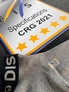 Nahaufnahme einer Diston DISTON WC Cut Resistant Unterhose Men - 5FIS Stars in CRG - PRO/ Racing Compression Fit, die auf einer strukturierten grauen Fläche neben einem FIS Certified S CALENDAR Zeichen liegt.