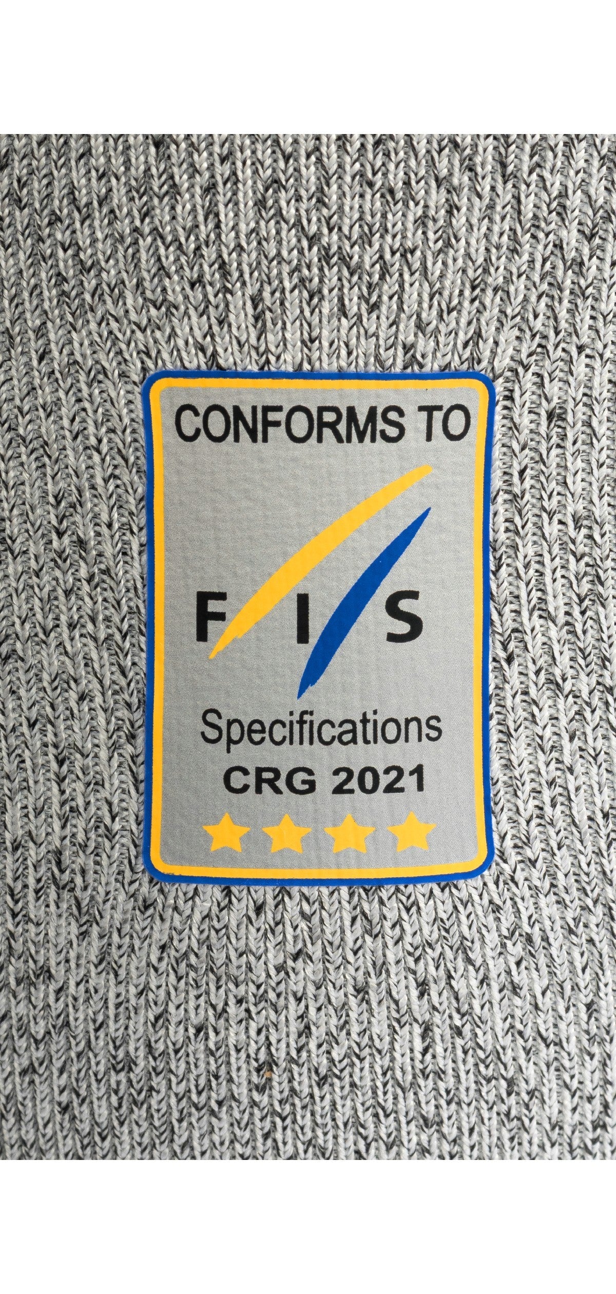 Die grau gestrickte Diston DISTON WC Schnittfeste Hosen Herren hat einen rechteckigen Aufnäher mit der Aufschrift "CONFORMS TO FIS Specifications CRG 2021" und vier goldenen Sternen, die blau und gelb umrandet sind - ein Qualitätsmerkmal für Skirennsport-Unterwäsche.