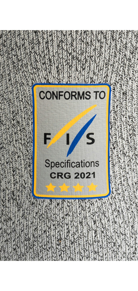 Die grau gestrickte Diston DISTON WC Schnittfeste Hosen Herren hat einen rechteckigen Aufnäher mit der Aufschrift "CONFORMS TO FIS Specifications CRG 2021" und vier goldenen Sternen, die blau und gelb umrandet sind - ein Qualitätsmerkmal für Skirennsport-Unterwäsche.