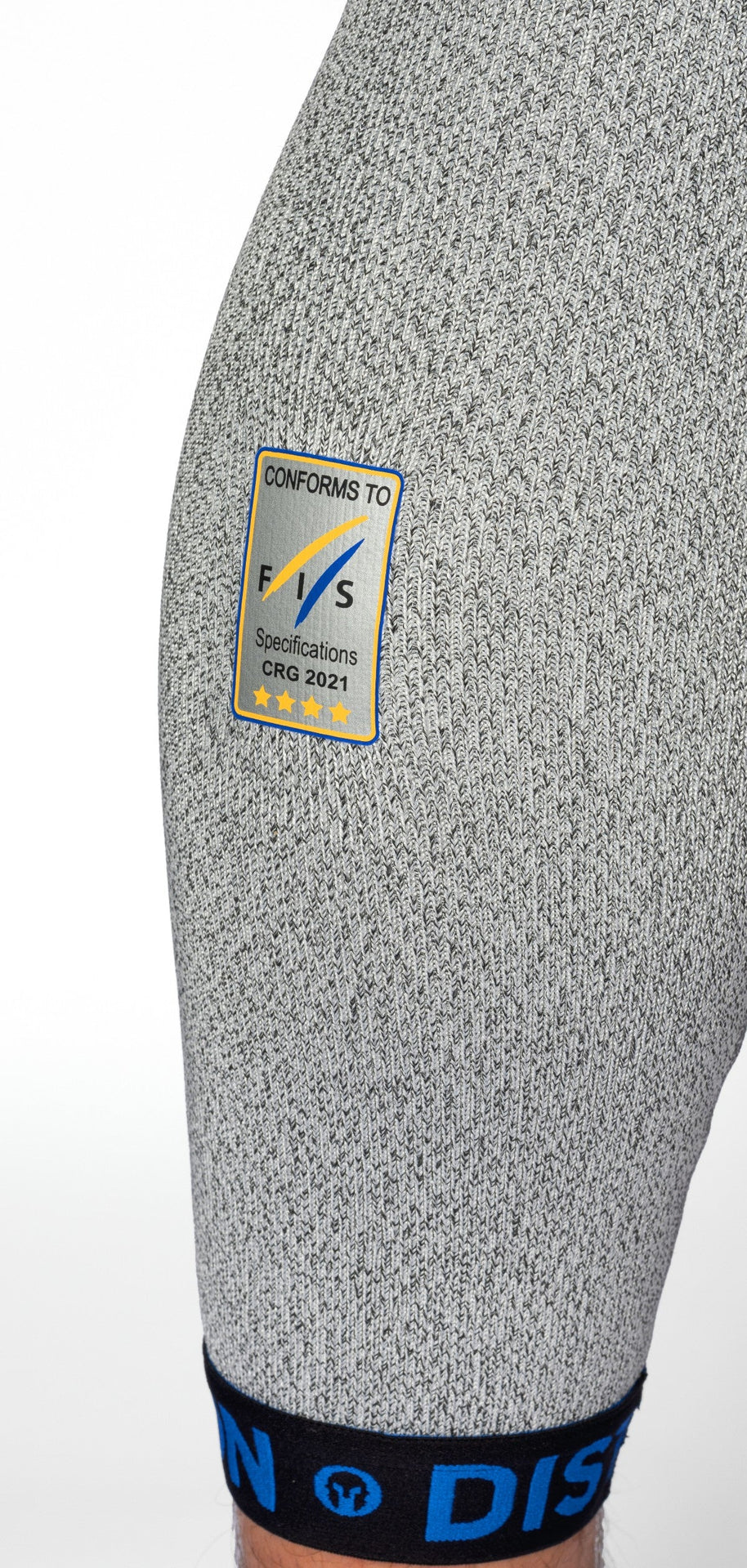 Nahaufnahme des Oberschenkels einer Person, die die grau strukturierten DISTON WC Schnittfeste Hosen Herren - 4FIS Stars in CRG - CORE / Racing Fit von Diston trägt, mit einem schwarz-blauen Bund und einem blau-gelben Etikett mit der Aufschrift Conforms to FIS Specifications, mit vier Sternen.