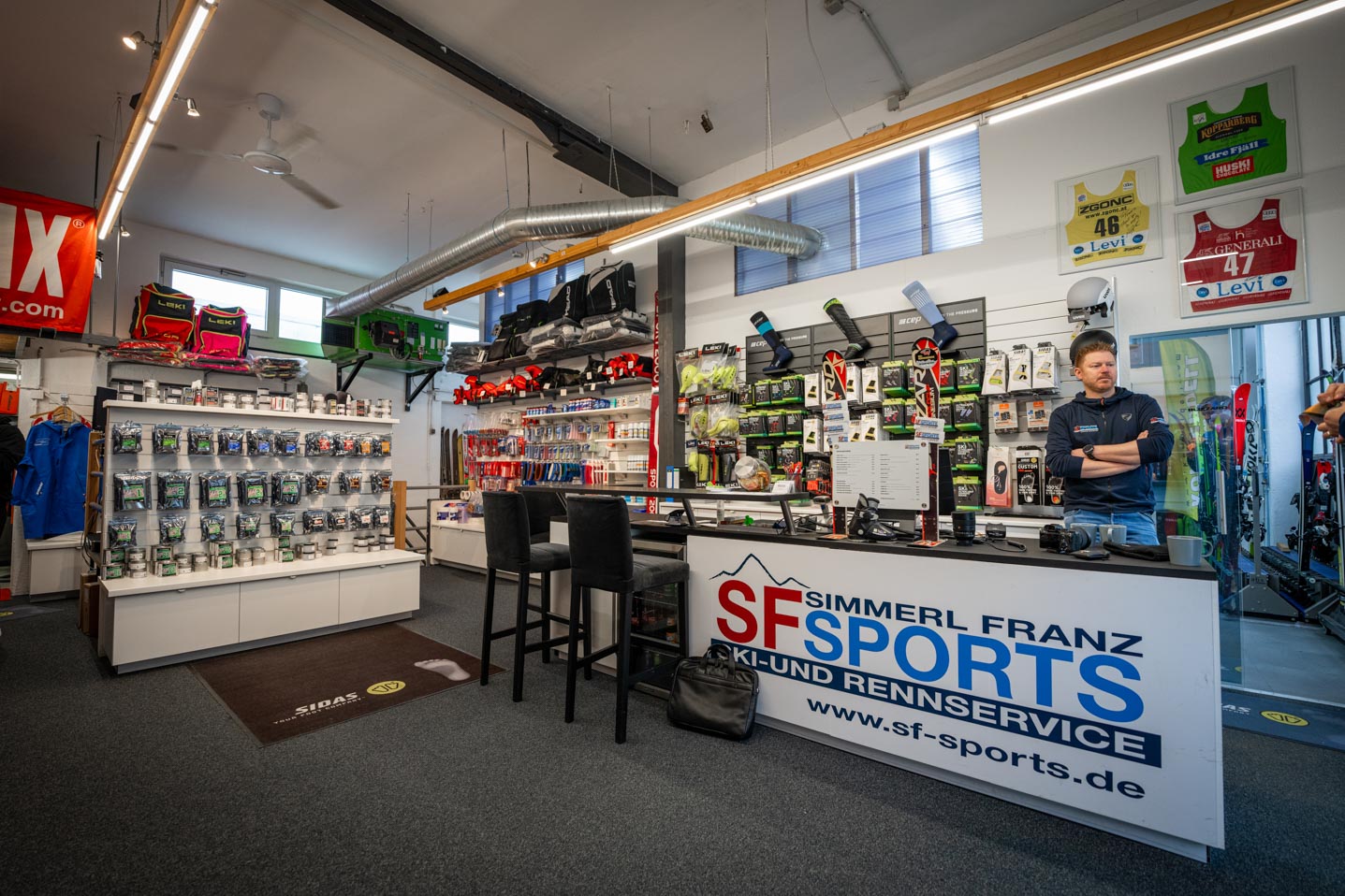 SF Sports Geschäft, ein Fachgeschäft in Gilching, spezialisiert auf Wintersportausrüstung für Skifahren und Snowboarding. Im Laden gibt es eine große Auswahl an Skiern, Snowboards, Skischuhen und Zubehör, die in einer modernen und einladenden Atmosphäre präsentiert werden.