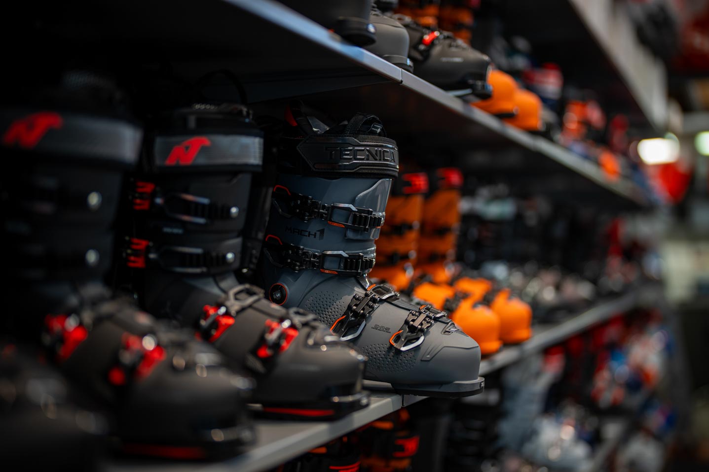 Ein Regal voller Skischuhe im SF Sports Geschäft. Verschiedene Modelle und Größen stehen zur Verfügung, um jedem Kunden die perfekte Passform und den besten Komfort für den Skisport zu bieten.