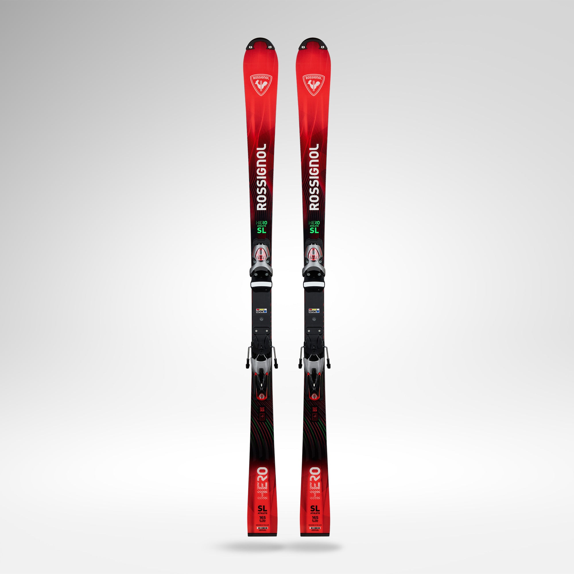 Ein Paar rot-schwarze Rossignol HERO FIS SL FAC 165 R22 2026/2027 Skier mit Bindung stehen aufrecht vor einem schlichten hellgrauen Hintergrund und zeigen die bekannte Weltcup-Performance von Rossignol.