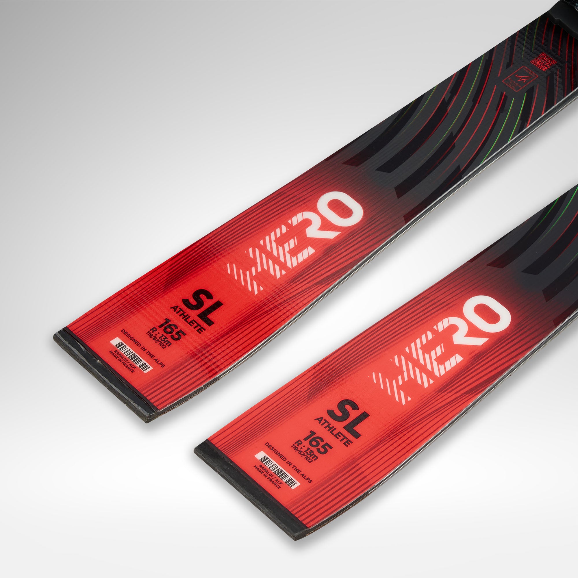 Nahaufnahme von zwei roten Rossignol HERO FIS SL 157 R22 2026/2027 Skiern mit schwarzen Akzenten und Etikett, die das moderne, FIS-konforme Design vor einem hellgrauen Hintergrund zeigen.
