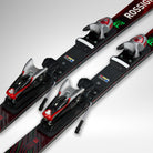 Nahaufnahme von zwei schwarzen Rossignol HERO FIS SL FAC 165 R22 2026/2027 Skiern mit Bindung, mit roten und silbernen Akzenten auf hellgrauem Grund. Ideal für Leistungen auf Weltcup-Niveau.