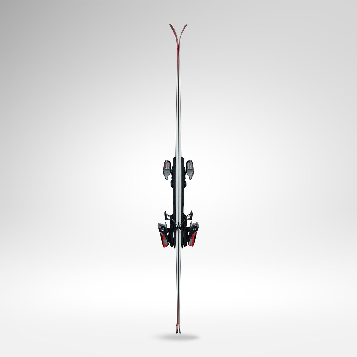 Ein Paar Rossignol HERO ATHLETE GS R22 2026/2027 Skier mit Bindung steht aufrecht, von vorne gesehen vor einem Hintergrund mit Gefälle. Die Spitzen sind oben nach oben gebogen und für U14- und U16-Rennläufer konzipiert.