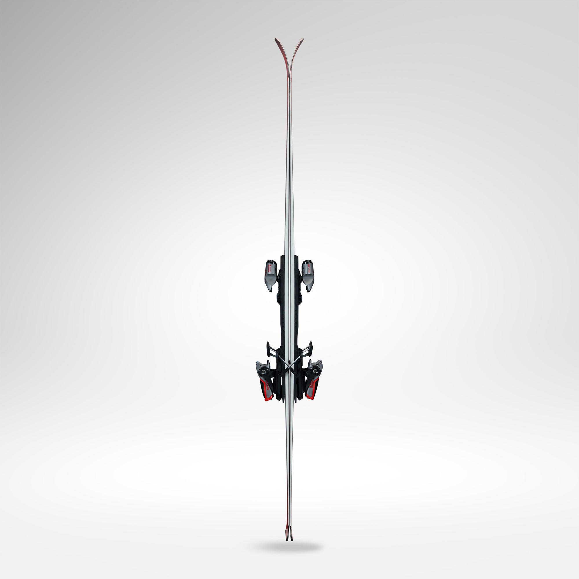 Ein Paar Rossignol HERO ATHLETE GS R22 2026/2027 Skier mit Bindung steht aufrecht, von vorne gesehen vor einem Hintergrund mit Gefälle. Die Spitzen sind oben nach oben gebogen und für U14- und U16-Rennläufer konzipiert.