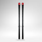 Ein Paar Rossignol HERO A FIS GS FAC 188 R22 2026/2027 Alpin-Ski mit schwarzem Karbonfasermuster und rotem Branding stehen aufrecht vor einem hellgrauen Hintergrund mit Farbverlauf.