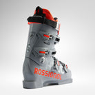 Der Rossignol HERO WORLD CUP ZA - POWER GREY 2026/2027 verfügt über vier Metallschnallen, einen schwarzen Riemen und ein rotes Rossignol-Branding, das sich vor einem hellen Hintergrund abhebt, um das World Cup Race Fit-Design zu unterstreichen.
