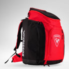 Eine rot-schwarze Rossignol HERO ATHLETES BAG mit weißem Rossignol-Logo und Schriftzug, mehreren Fächern mit Reißverschluss, gepolsterten Trägern und einer robusten Konstruktion – ideal als wasserdichter Skirucksack zum Transportieren deiner gesamten Skirennausrüstung und aller wichtigen Utensilien.