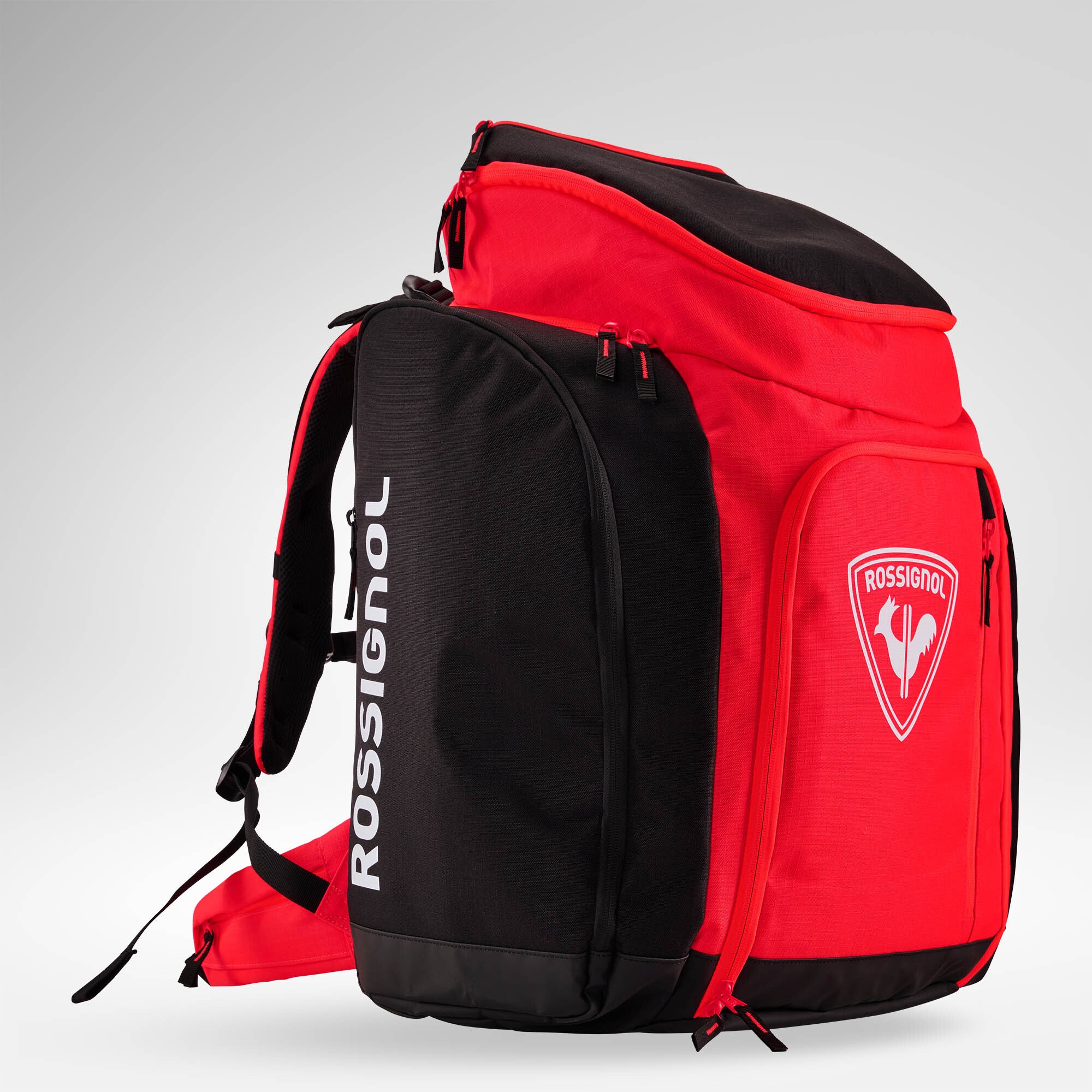 Eine rot-schwarze Rossignol HERO ATHLETES BAG mit weißem Rossignol-Logo und Schriftzug, mehreren Fächern mit Reißverschluss, gepolsterten Trägern und einer robusten Konstruktion – ideal als wasserdichter Skirucksack zum Transportieren deiner gesamten Skirennausrüstung und aller wichtigen Utensilien.