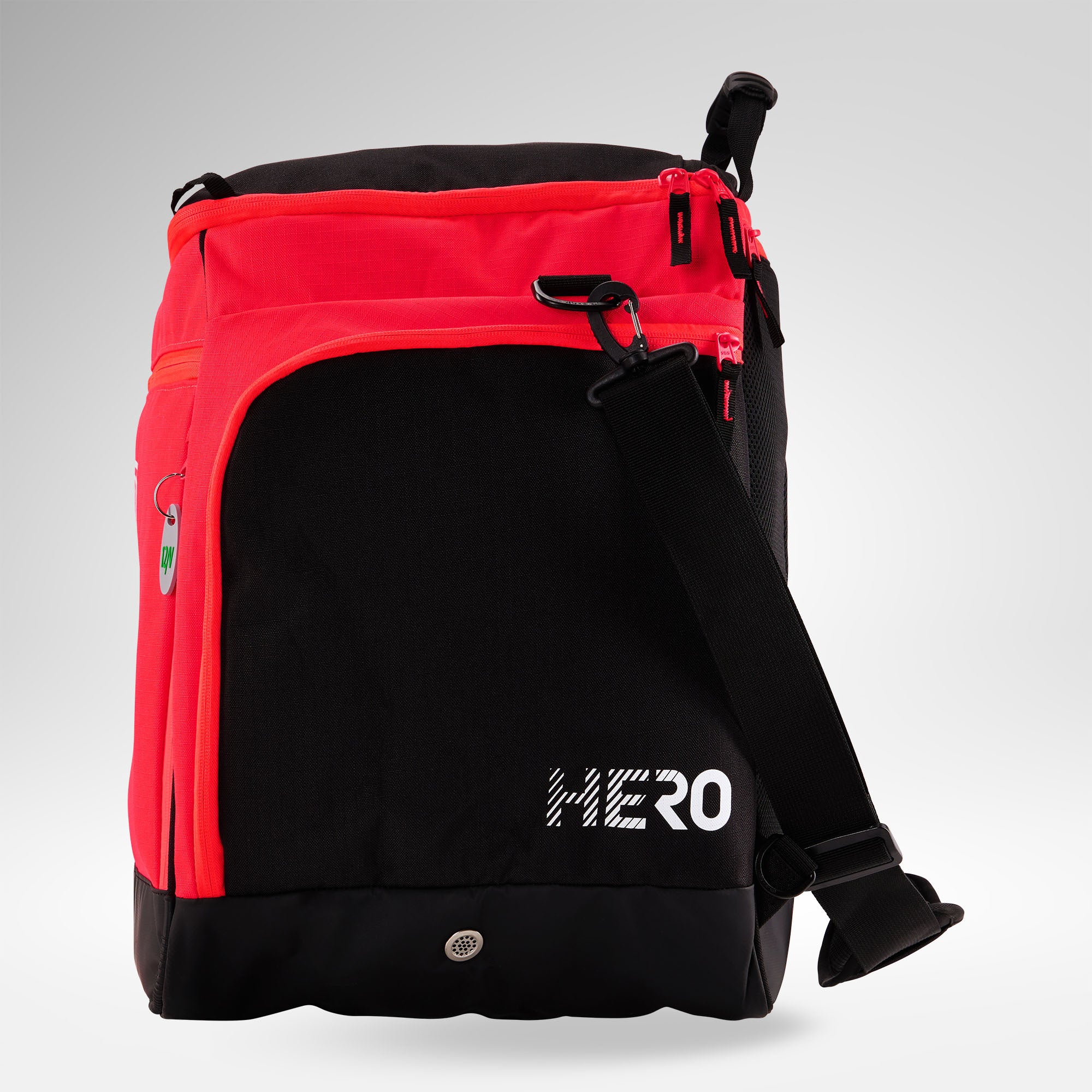 Ein Rossignol HERO HEATED BAG 230V in Schwarz und Rot, mit dem Schriftzug „HERO“ in Weiß auf der Vorderseite, mehreren Reißverschlusstaschen und einem verstellbaren Trageriemen, dargestellt vor einem hellgrauen Hintergrund.