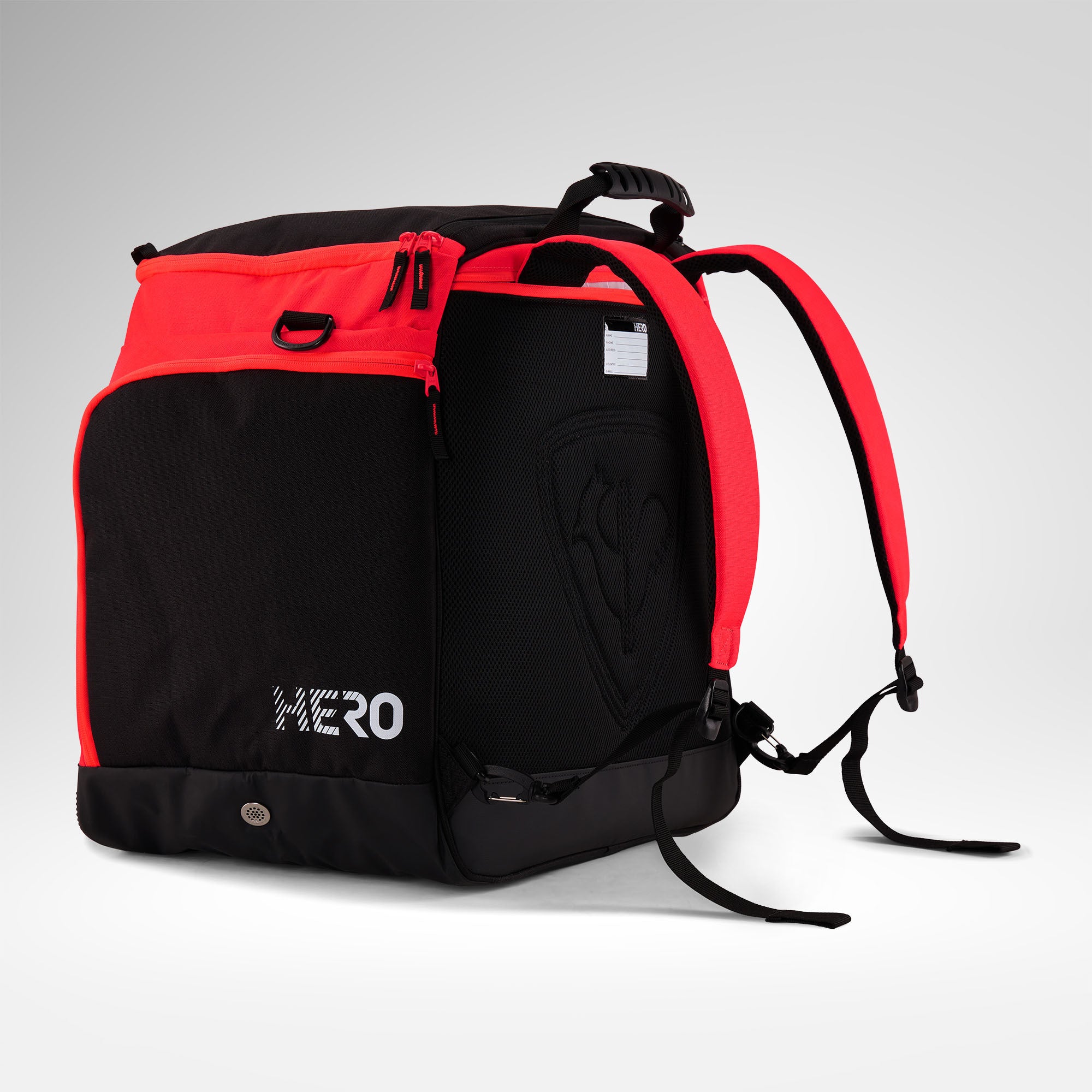 Der Rossignol HERO HEATED BAG 230V, ein schwarz-roter Rucksack mit der Aufschrift „HERO“ an der Seite, verfügt über gepolsterte Schultergurte und mehrere Fächer. Vor einem schlichten hellgrauen Hintergrund präsentiert, ist er die perfekte Skischuhtasche oder beheizbare Stiefeltasche, um Ihre Ausrüstung ordentlich zu verstauen und warm zu halten.