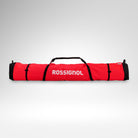 Eine rote Rossignol HERO SKI BAG 2/3P ADJUSTABLE 190/220 mit schwarzen Riemen und Tragegriffen, von vorne vor einem schlichten weißen Hintergrund abgebildet. Diese wasserdichte Skitasche von Rossignol eignet sich ideal, um 2–3 Paar Ski sicher und stilvoll zu transportieren.