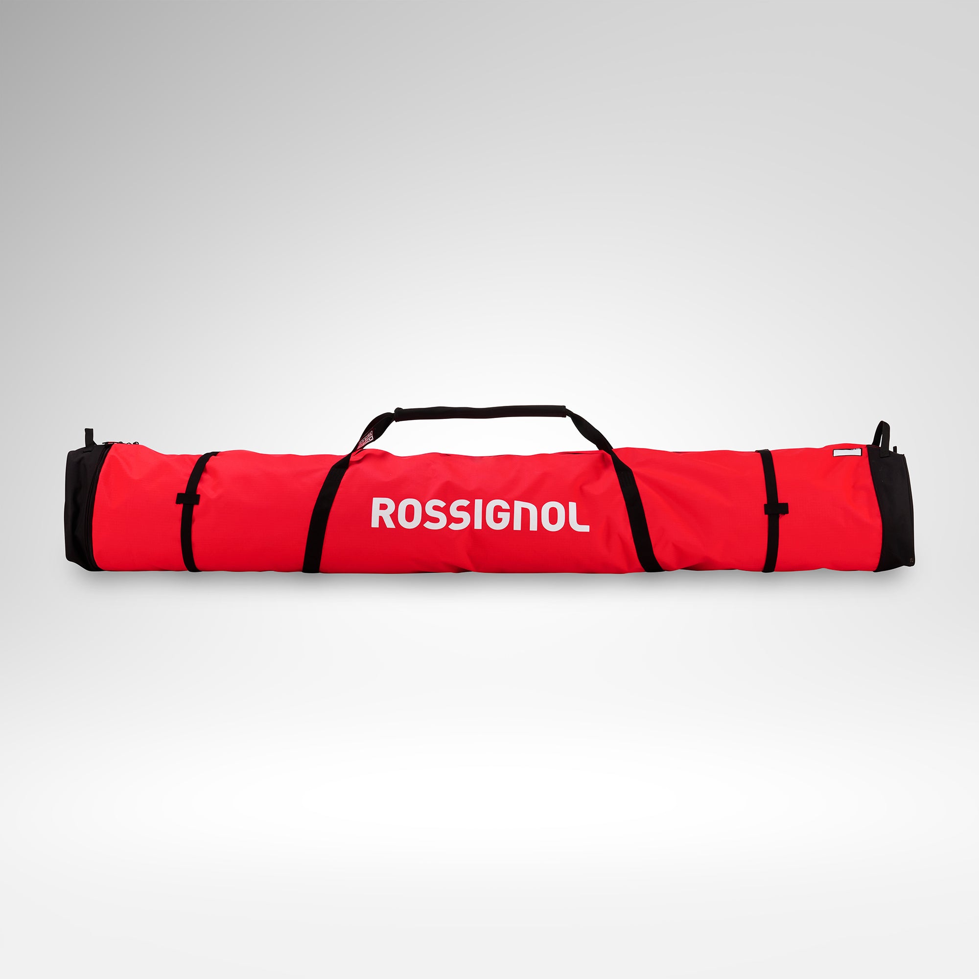 Eine rote Rossignol HERO SKI BAG 2/3P ADJUSTABLE 190/220 mit schwarzen Riemen und Tragegriffen, von vorne vor einem schlichten weißen Hintergrund abgebildet. Diese wasserdichte Skitasche von Rossignol eignet sich ideal, um 2–3 Paar Ski sicher und stilvoll zu transportieren.