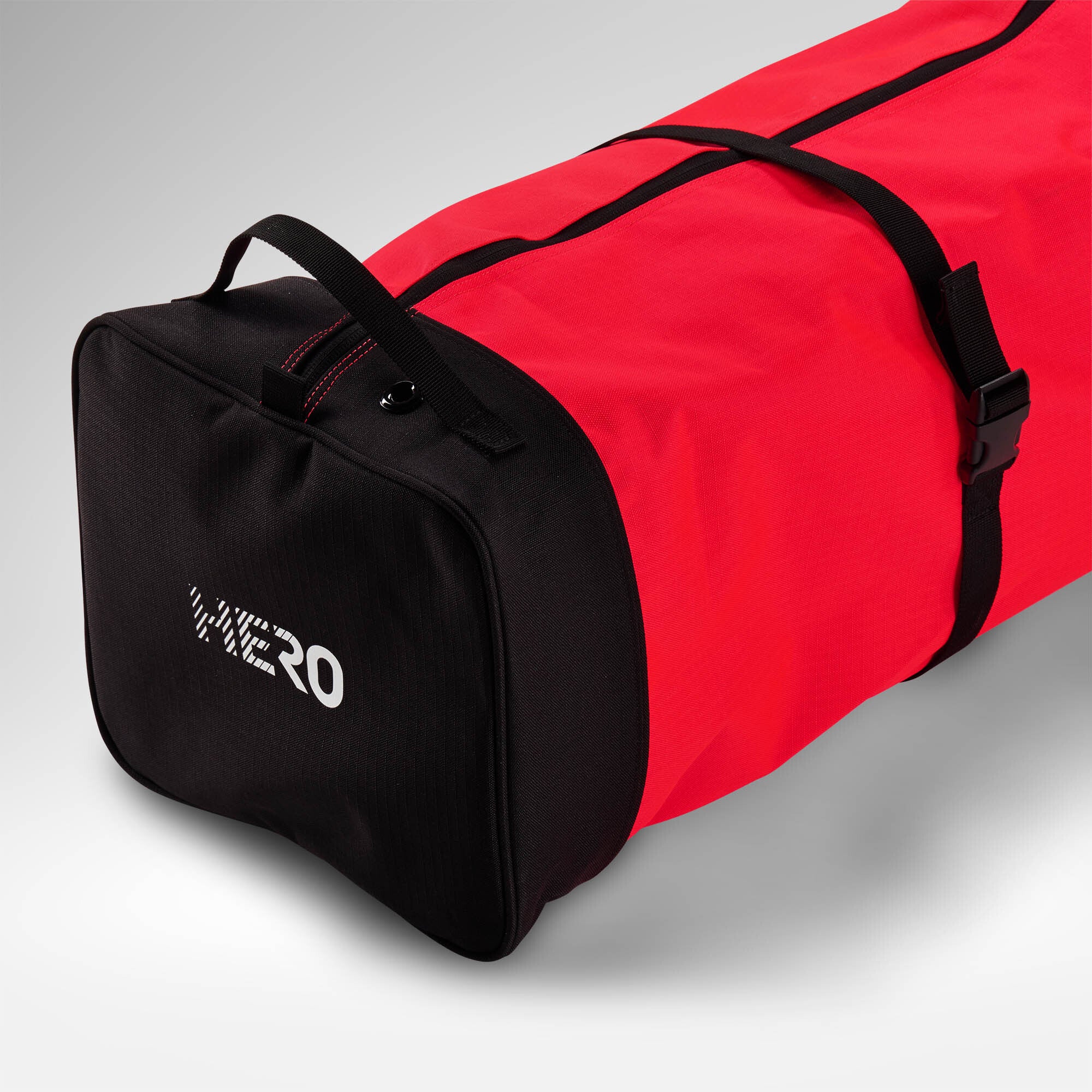 Eine rot-schwarze Rossignol HERO SKI BAG 2/3P ADJUSTABLE 190/220 mit dem ikonischen weißen Rossignol-Logo auf der schwarzen Endseite ist vor einem hellgrauen Hintergrund abgebildet– perfekt als Skitasche für 220 cm, die reichlich Platz und Stil für Ihr nächstes Skiabenteuer bietet.