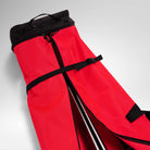 Eine rot-schwarze Rossignol HERO SKI BAG 2/3P ADJUSTABLE 190/220 mit schwarzen Riemen und Reißverschlüssen ist teilweise geöffnet abgebildet, sodass die darin befindliche Sportausrüstung auf einer hellgrauen Unterlage zu sehen ist – was das robuste Design unterstreicht, das an die renommierte Marke Rossignol erinnert.