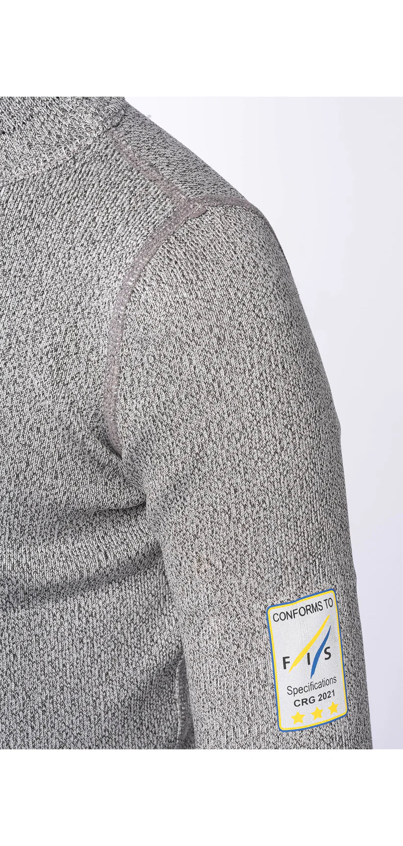 Nahaufnahme des Oberarms eines Junior-Skirennfahrers in dem grauen, strukturierten Diston DISTON Cut Resistant Top Junior - 3FIS Stars in CRG - BASE / Performance Fit. Ein Ärmelaufnäher weist auf die Konformität mit F.I.A. 8856-2018 CIK-FIA 2021 für schnittfeste Unterwäsche hin.