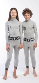 Ein Mädchen und ein Junge stehen nebeneinander, barfuß und lächelnd. Sie tragen zusammenpassende Diston Cut Resistant Top Junior - 3FIS Stars in CRG - BASE / Performance Fit Thermo-Oberteile und Hosen vor einem weißen Hintergrund.