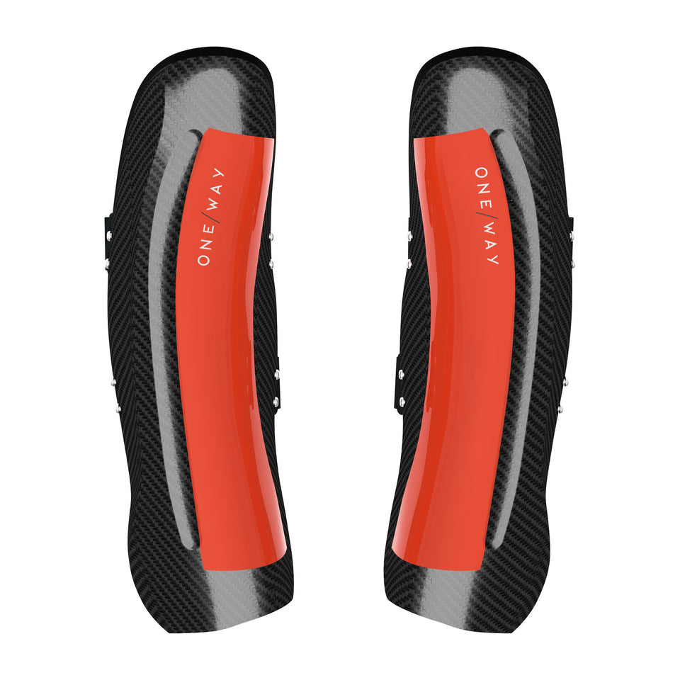 Ein Paar One Way Carbon Shin Guard WC Pro mit einem schwarz-roten Karbonfasermuster und dem Schriftzug "ONE WAY" in Weiß auf dem roten Mittelstreifen auf weißem Hintergrund.